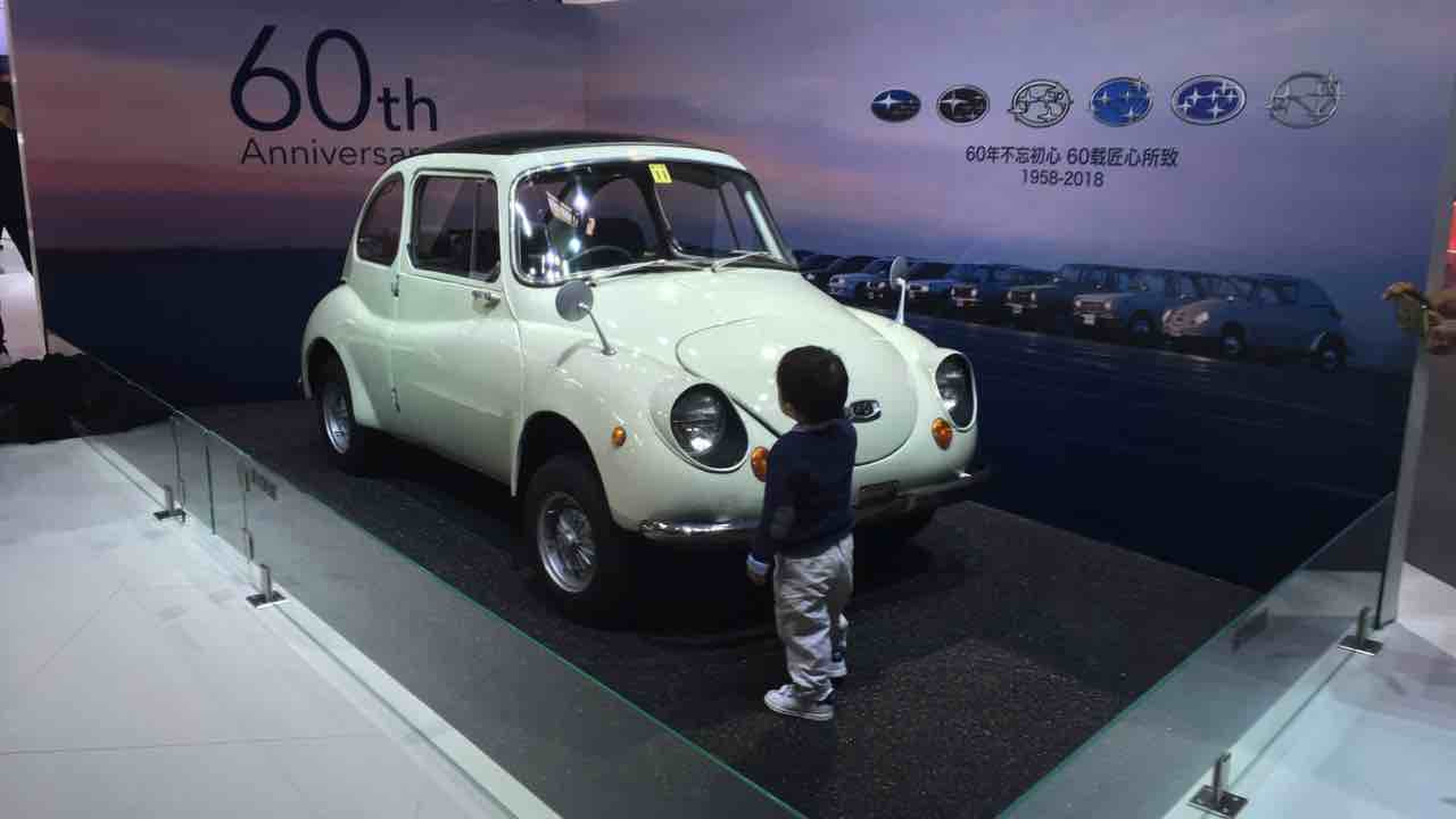 Un niño mira el Subaru 360 de 1958