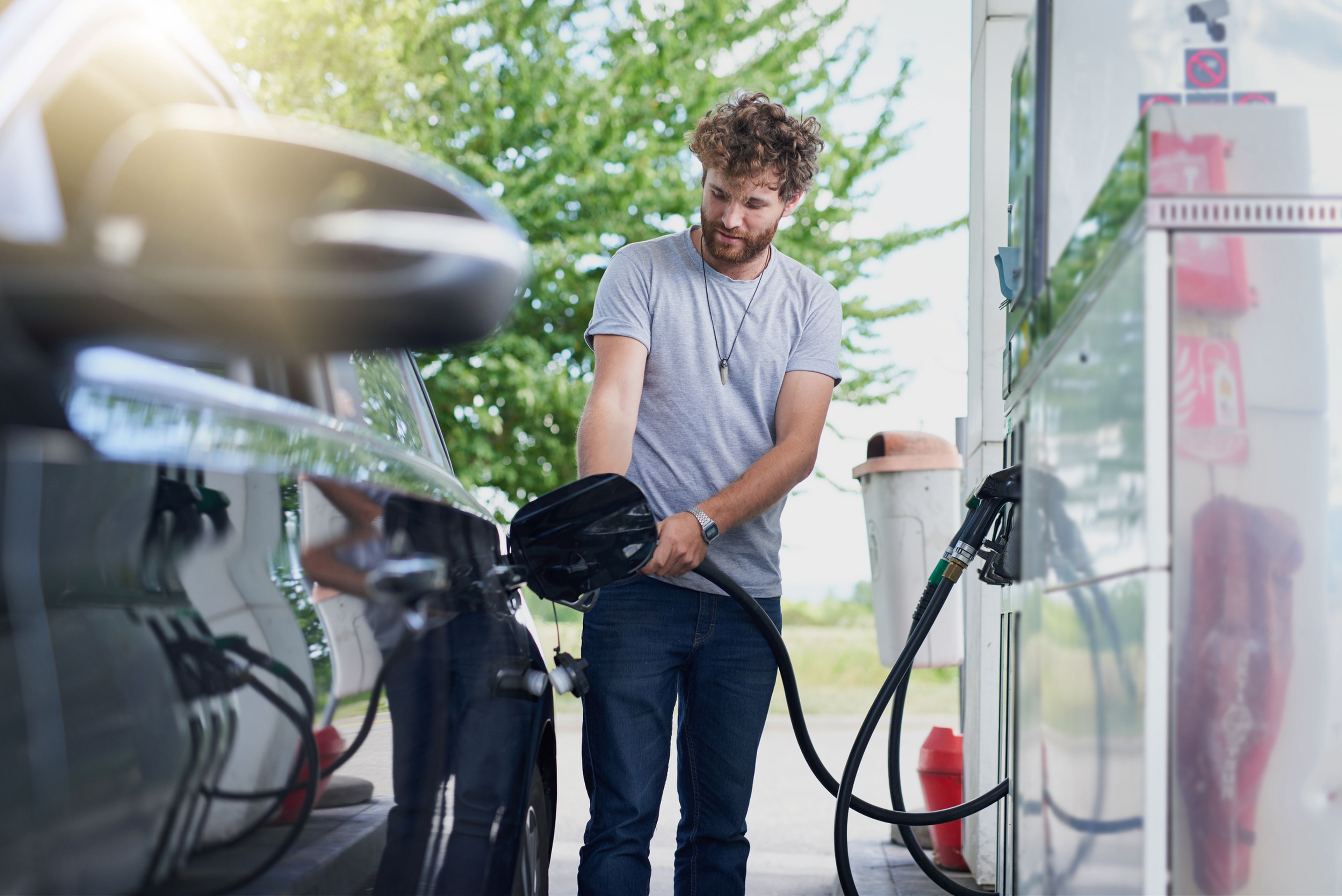 Hombre en la gasolinera llenando el depósito de su coche de combustible