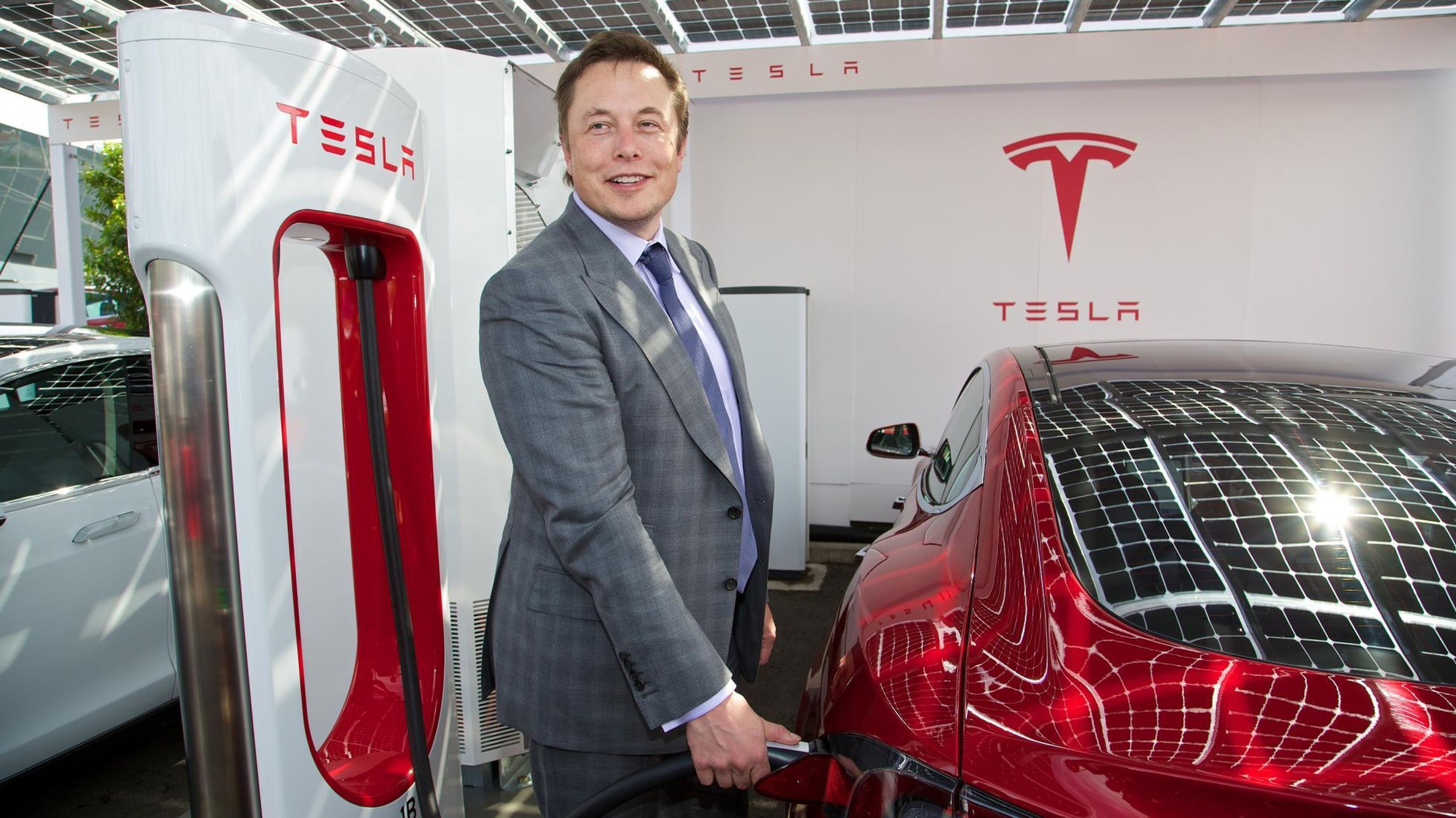 Elon Musk recargando un Tesla