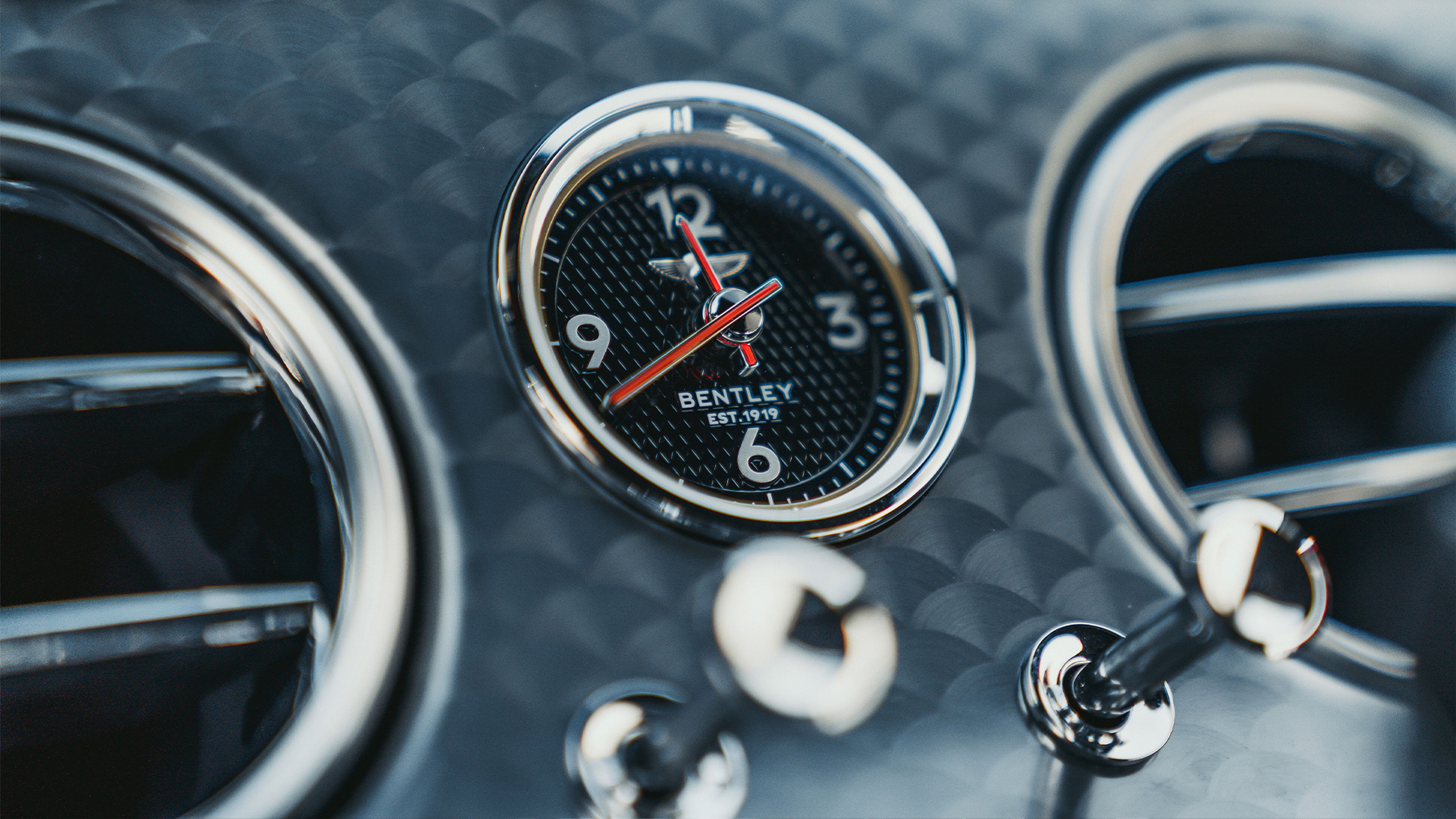 Reloj analógico y válvulas del aire acondicionado en el Bentley Continental GT Speed.