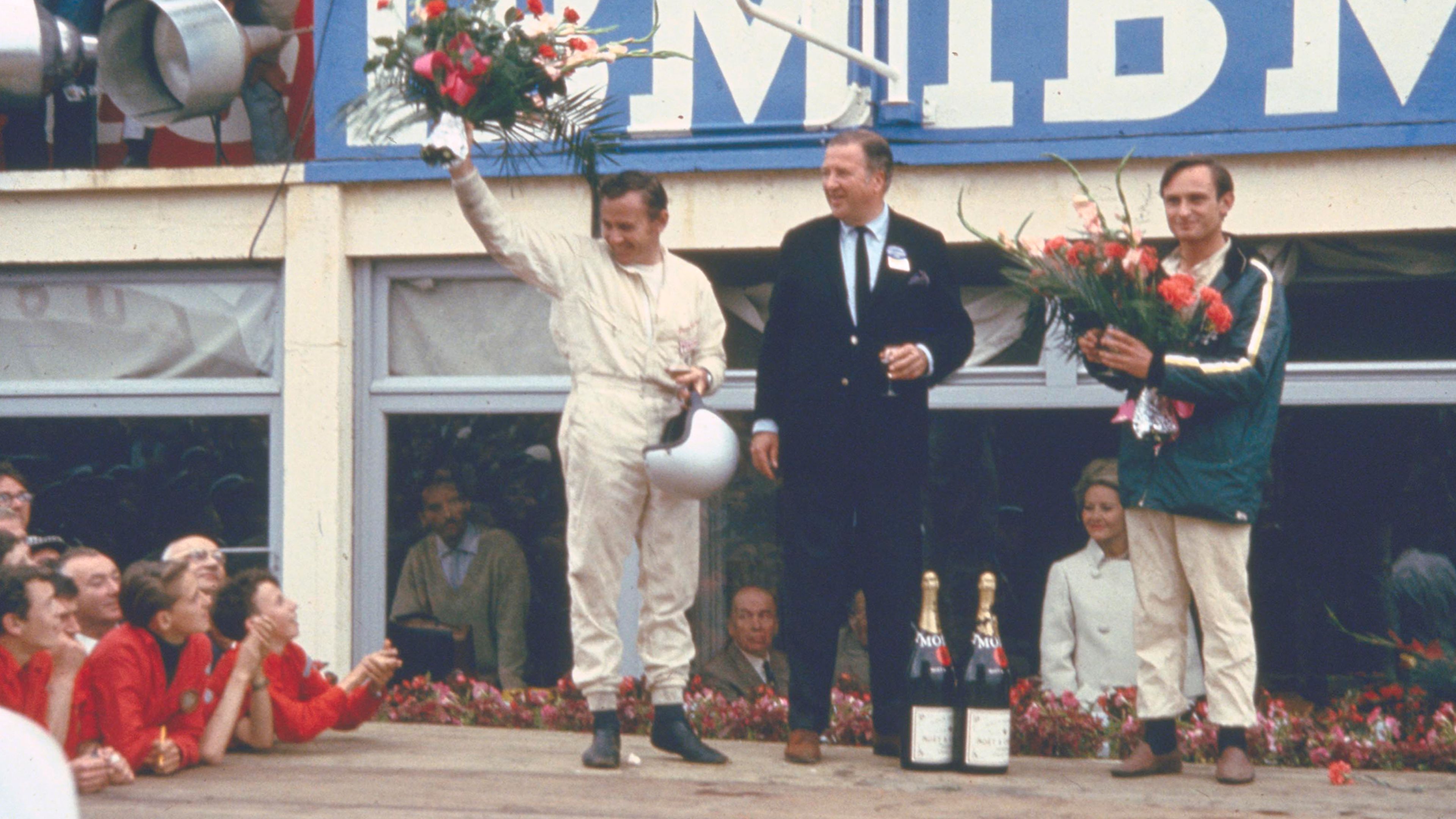 Bruce McLaren (izquierda), Henry Ford II (centro) y Chris Amon (derecha) durante la victoria en Le Mans de 1966.