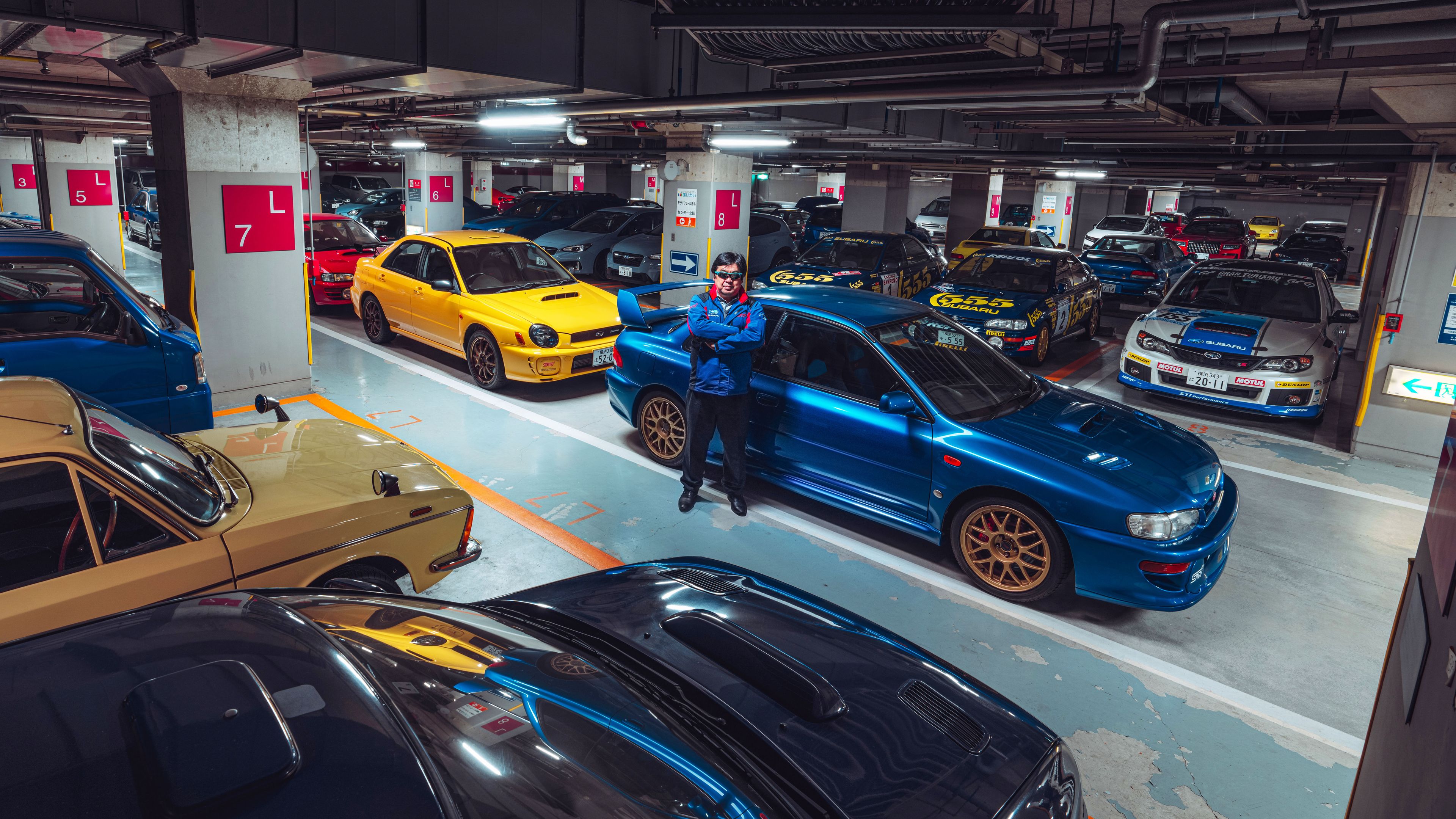 Akira Yokohama, con su colección de Subaru en un parking de Japón